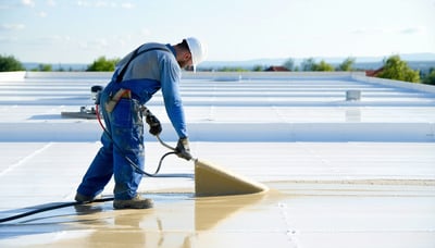 Technician applying protective coating on a roof Technician applying protective coating on a roof